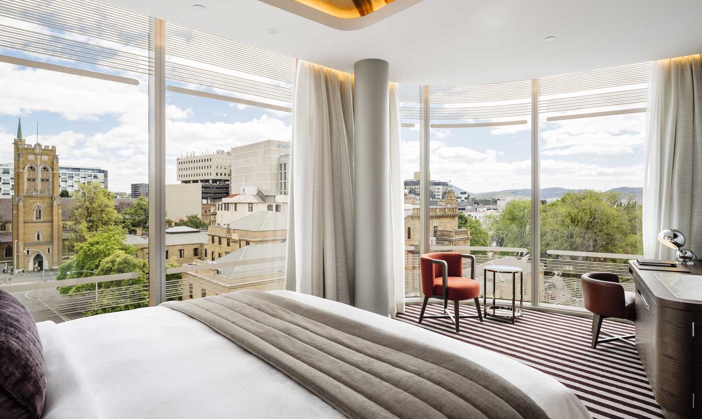 Tasman hotel bedroom with floor-to-ceiling city views